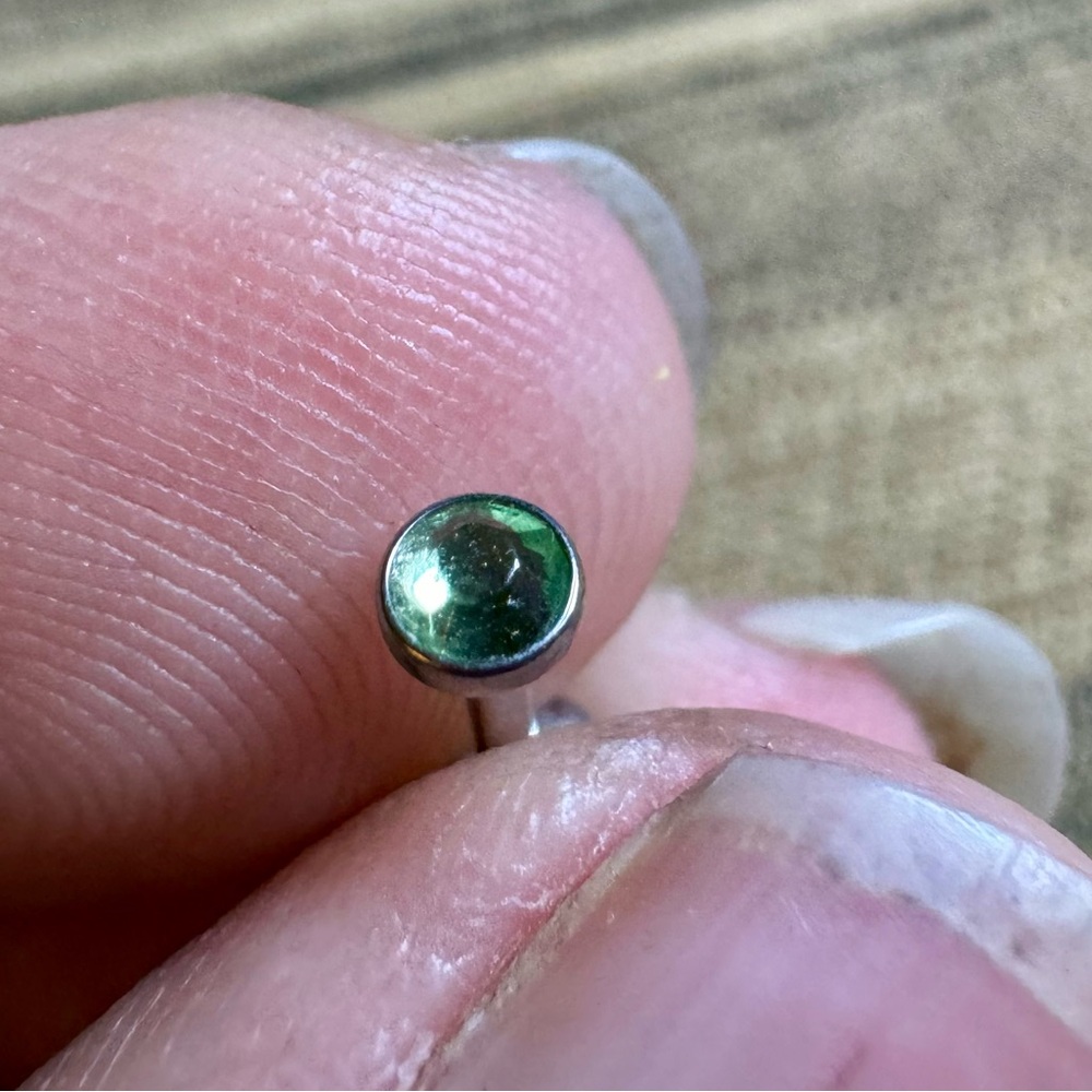 16g stud with green faceted stone.